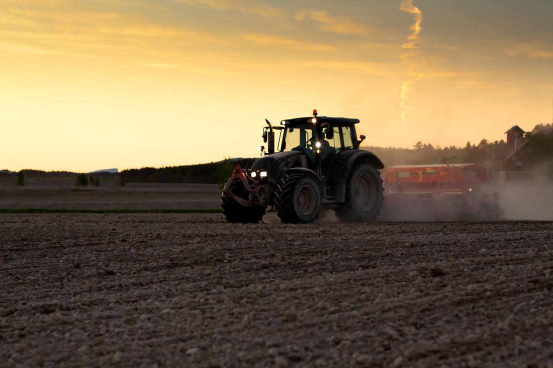 illustrasjonsbilde traktor på et jorde i solnedgang