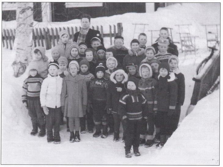 Gruppe barn fotografert utendørs på vinteren. Mye snø og barna godt kledd i vinterklær